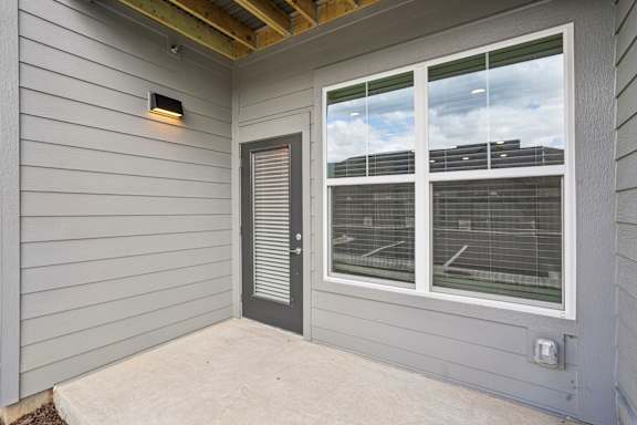 A grey house with a window and a door.