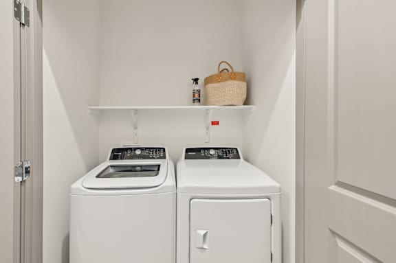 A small laundry room with a washer and dryer.