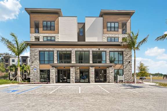 A modern two-story building with a parking lot in front. at The Concord Luxury Apartments, Sarasota 34240