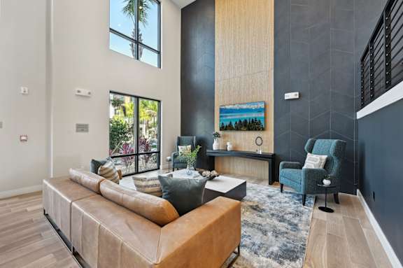 A modern living room with a large sectional sofa and a painting on the wall at The Concord Luxury Apartments, Sarasota