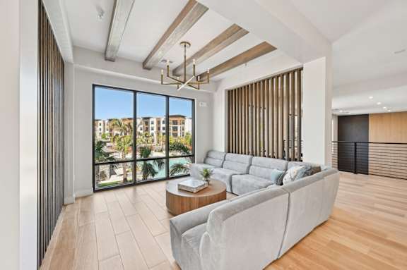 A modern living room with a grey sofa and a view of the city. at The Concord Luxury Apartments, Sarasota, FL