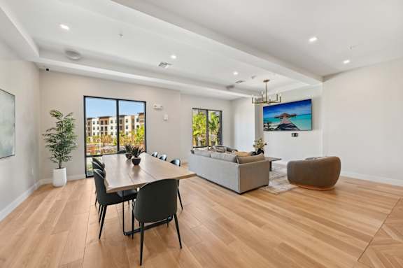A modern living room with a wooden floor and a large window. at The Concord Luxury Apartments, Sarasota, Florida