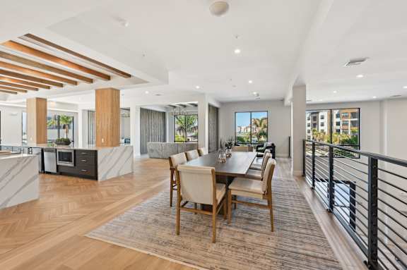 A modern dining room with a wooden table and chairs at The Concord Luxury Apartments, Sarasota 34240