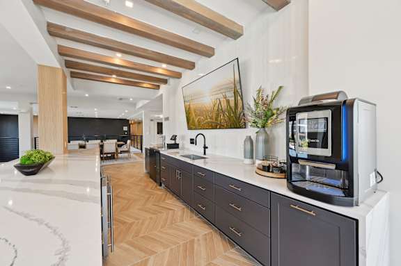 A modern kitchen with dark wood cabinets and a white countertop. at The Concord Luxury Apartments, Sarasota, Florida