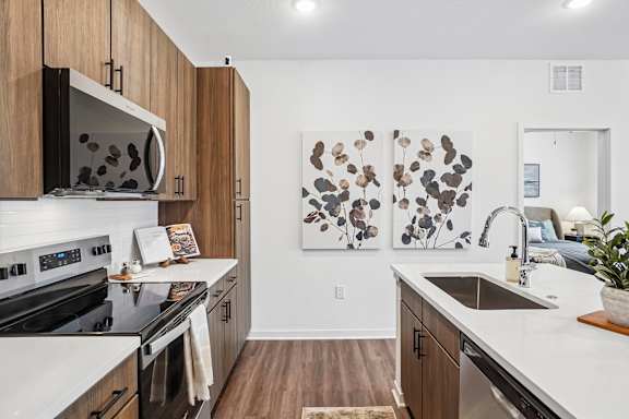 A modern kitchen with dark wood cabinets and white countertops.