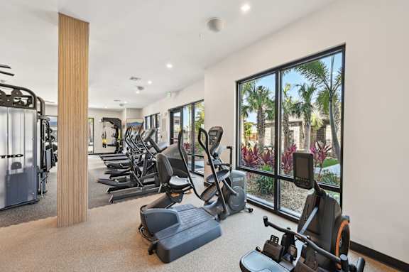 A gym with a variety of equipment including treadmills, weights, and exercise machines. at The Concord Luxury Apartments, Florida