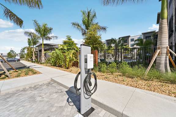 A charging station for electric vehicles is located on a sidewalk at The Concord Luxury Apartments, Sarasota, FL