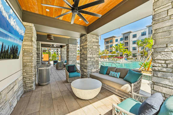 A patio with a white table and blue cushions at The Concord Luxury Apartments, Sarasota
