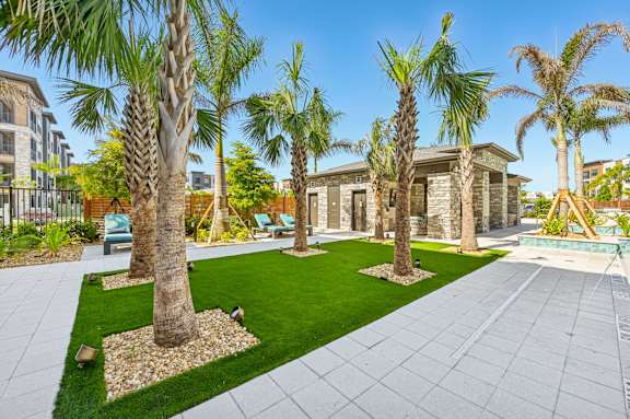 A row of palm trees are planted in a garden at The Concord Luxury Apartments, Sarasota, FL, 34240