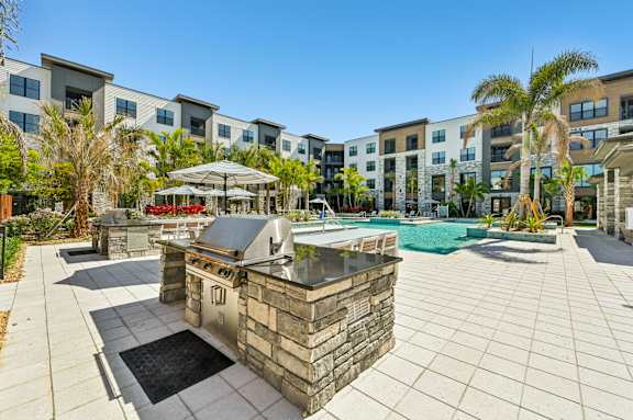 A pool area with a stone fountain in the middle of a patio at The Concord Luxury Apartments, Sarasota 34240