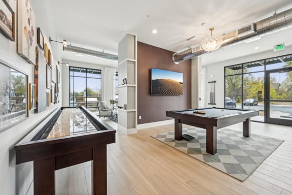 a billiards room with a pool table and a large window at The Quarry Luxury Apartment Homes, Fort Collins, CO