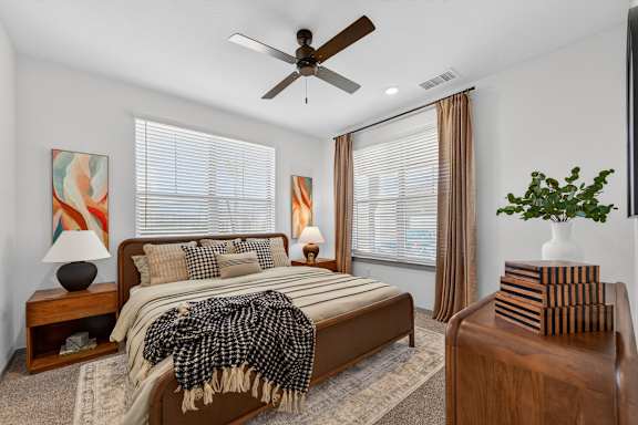 A bedroom with a bed, a ceiling fan, and a painting on the wall.at Refinery at Pointe17 Apartments, Phoenix, AZ, 85085
