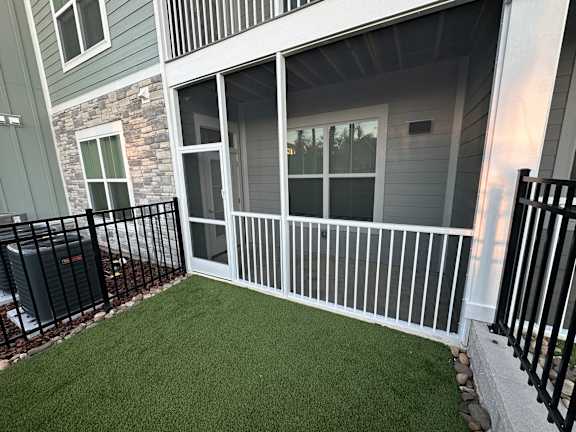 A balcony with a black railing and a green lawn at Standard441 Luxury Apartments, Lady Lake, FL