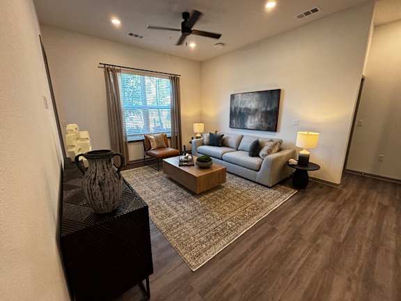 A living room with a black piano and a rug.