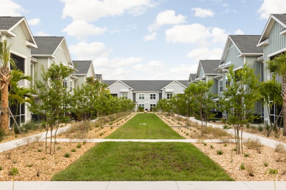 a row of houses with lawns and trees at Palm Grove in Ellenton, FL 34222