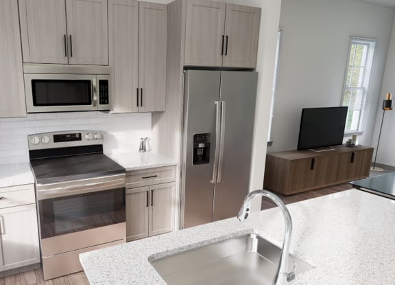 a kitchen with stainless steel appliances and white counter tops at The Hadley Luxury Apartments, North Port, Florida