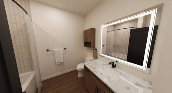 A bathroom with a white sink, toilet, and a mirror with a black screen.