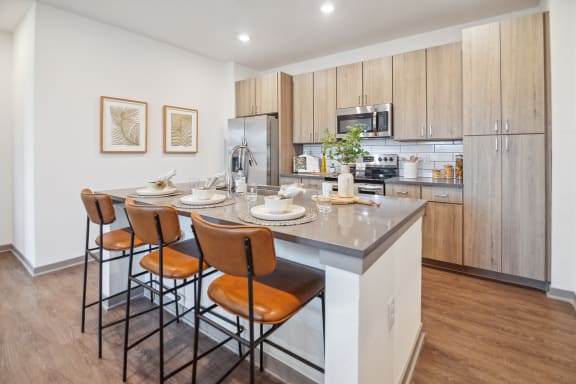 a kitchen with a large island with stools and a table with chairs  at Palm Grove, Ellenton, Florida