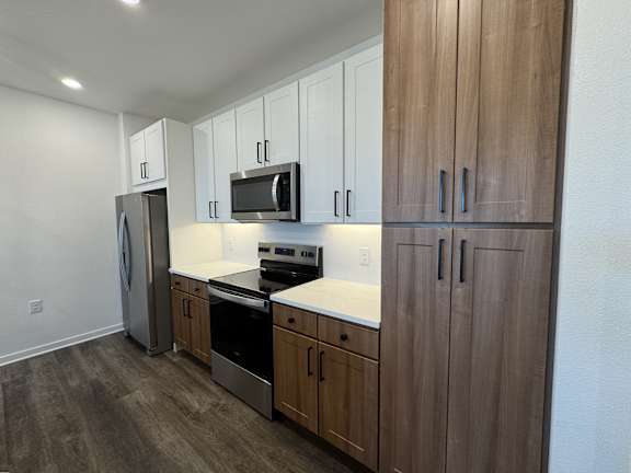 A kitchen with wooden cabinets and stainless steel appliances. at The Junction at Rockledge Apartments, Florida