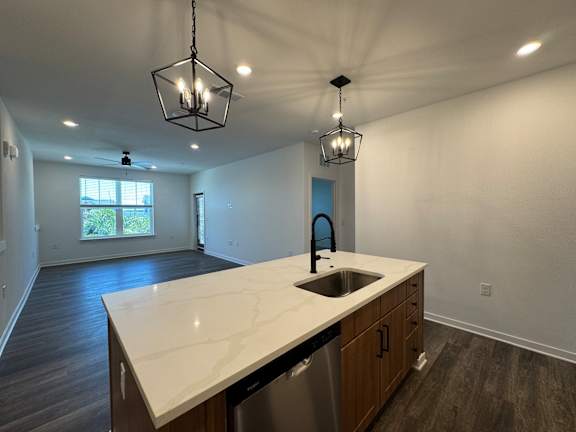 A kitchen with a white countertop and wooden cabinets. at The Junction at Rockledge Apartments, Rockledge