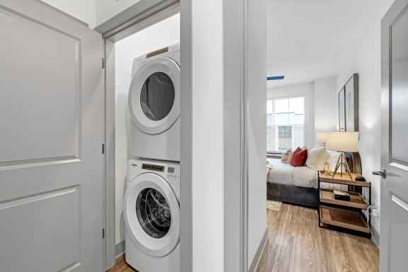 a front loading washer and dryer in a living room with a bedroom at Meridian at CityPlace, Woodbury, MN