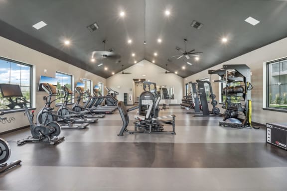 a gym with cardio machines and weights on the floor at The Depot in The Depot Raymore, MO 64083