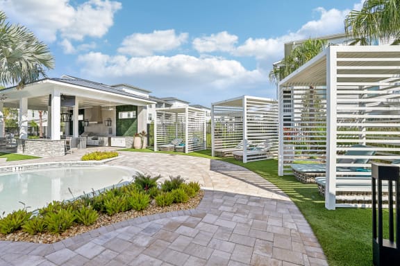 a backyard with a pool and a house with white structures at Drift, Daytona Beach, FL, 32117