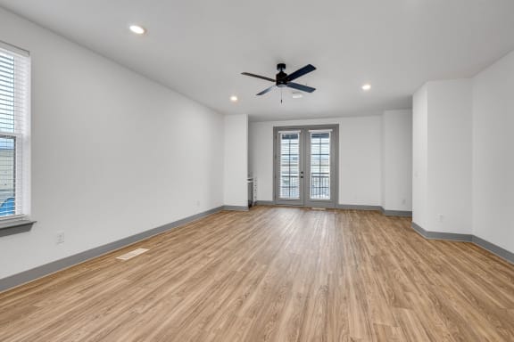 an empty living room with white walls and a ceiling fan at Meridian at CityPlace, Woodbury, MN