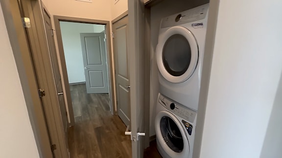A washing machine is in a small room with a door open.
