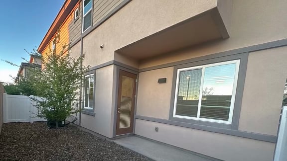 a side view of a house with a door and a tree at Grandstone at Sunrise, Peoria, 85383