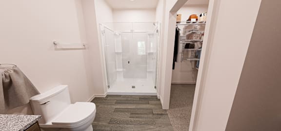 A white toilet in a bathroom with a walk in shower at Verity Luxury Apartment Homes Apartments, Vero Beach
