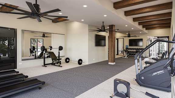 A spacious home gym with a variety of exercise equipment at The Stadler Luxury Apartments, Florida 34210
