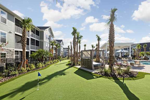 A miniature golf course is surrounded by palm trees and a pool at Standard441 Luxury Apartments, Lady Lake, Florida