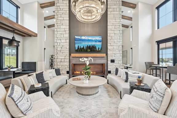A modern living room with a fireplace and a large TV above it.at The Garrison Luxury Apartment Homes, Fountain, CO