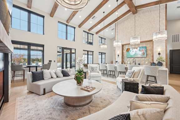 A large, well-lit living room with a variety of seating options and a central coffee table.at The Garrison Luxury Apartment Homes, Fountain, CO 80817