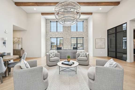 A living room with grey chairs and a coffee table.at The Garrison Luxury Apartment Homes, Colorado