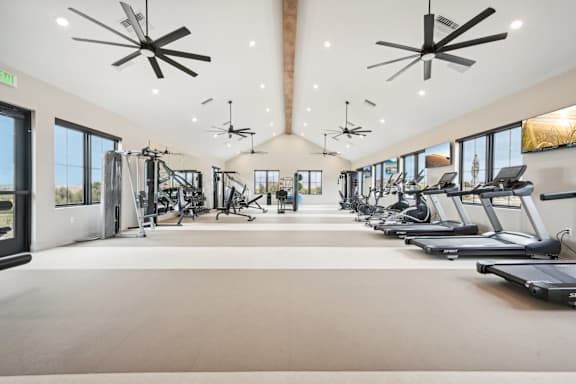 A spacious gym with treadmills, exercise bikes, and other equipment.at The Garrison Luxury Apartment Homes, Fountain, 80817