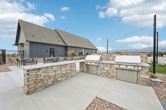 A house with a stone wall and a garage.at The Garrison Luxury Apartment Homes, Fountain Colorado