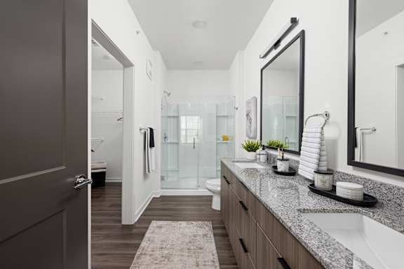 A bathroom with a sink, mirror, and toilet. at The Levi Luxury Apartments, McDonough, GA, 30253