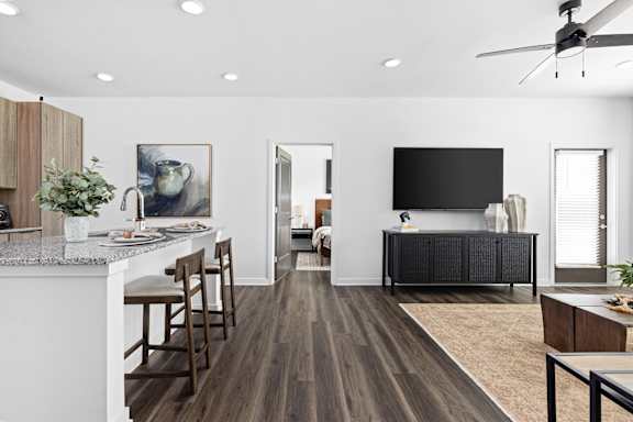 A modern kitchen with a bar area and a television.