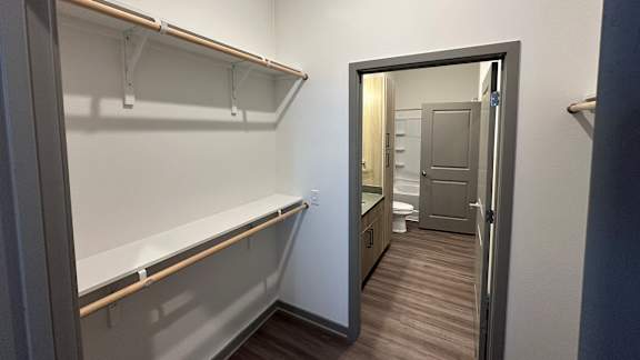 A walk in closet with shelves.