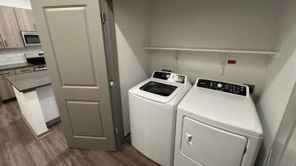 A white washing machine and dryer in a laundry room.
