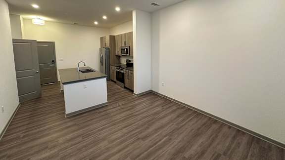 A kitchen with a refrigerator, sink, and oven.