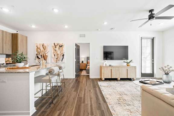 A modern living room with a kitchen area in the background at Verity Luxury Apartments, Florida