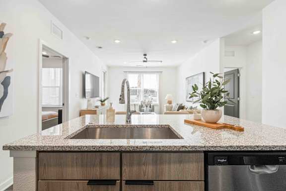 A modern kitchen with a granite countertop and stainless steel appliances at Verity Luxury Apartments, Florida 32960