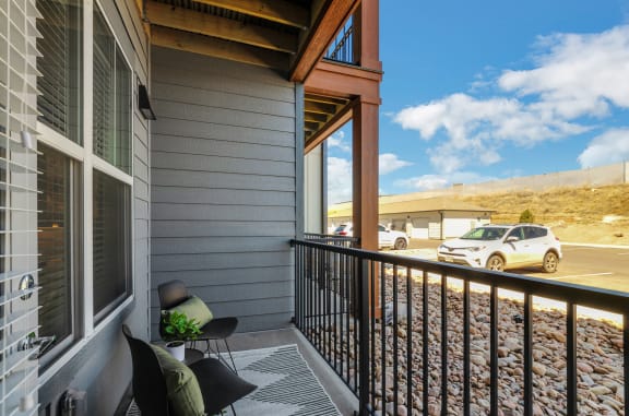 a balcony with a view of a parking lot and a car  at Upland Flats, Colorado Springs, 80922