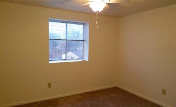 A room with a window and a ceiling fan.