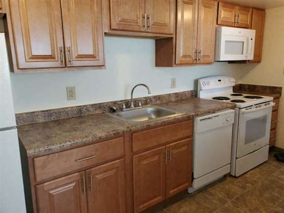 A kitchen with brown cabinets and a white oven.