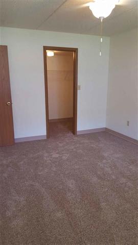 A room with a carpeted floor and a door.