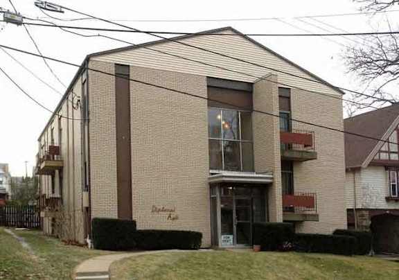A two-story building with a brown door and windows.